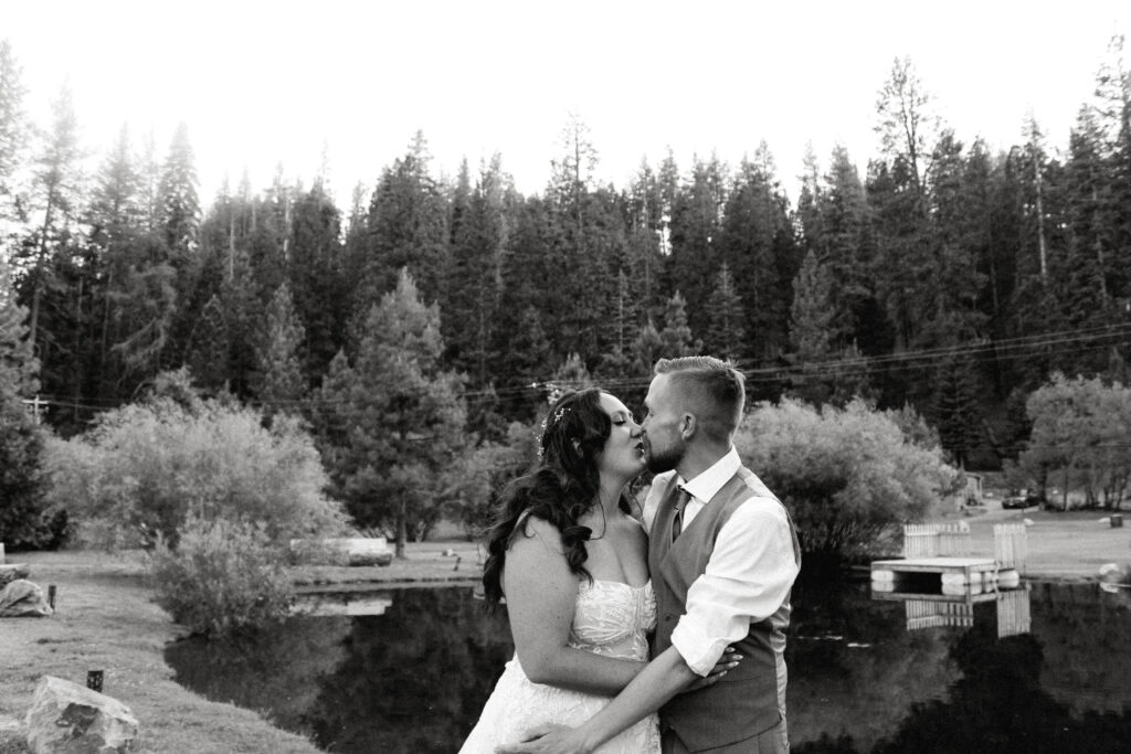 A candid documentary-style photo of a couple embracing amid the breathtaking landscape of Lassen National Park. The pair is surrounded by lush greenery, rugged volcanic terrain, and a serene, natural backdrop, showcasing their connection in an unposed, authentic moment. Perfect for capturing the beauty of love in a wild and natural setting.