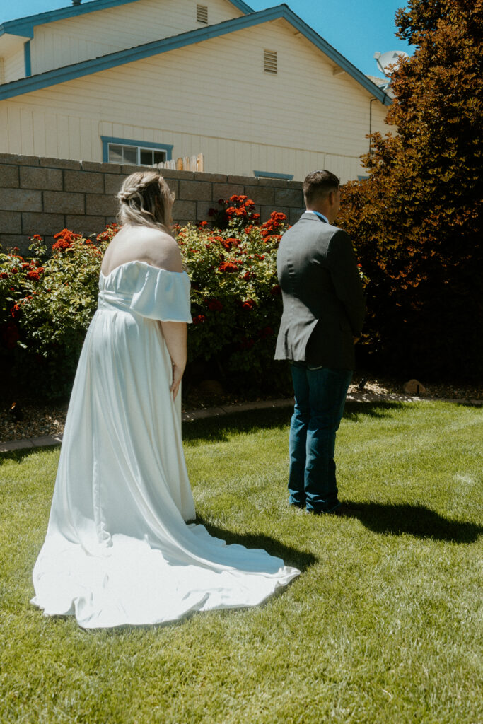 A heartfelt first look captured by a Tucson wedding photographer: The groom turns to see his bride for the first time, surrounded by the warm hues of the Arizona desert, creating a timeless and emotional moment.