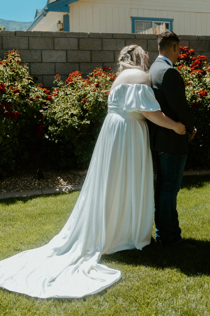 An intimate first look moment captured by a Tucson wedding photographer: The groom turns with a joyful expression as he sees his bride in her wedding gown, set against the picturesque Arizona desert landscape.